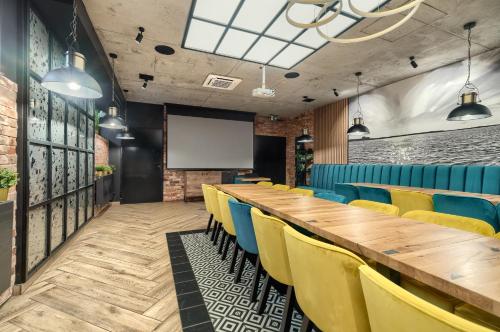 a conference room with a long table and yellow chairs at Stawa Villa & Apart in Świnoujście