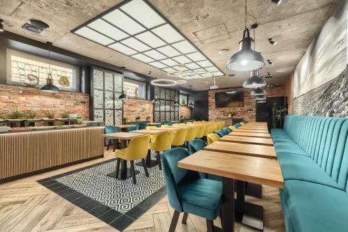 a restaurant with wooden tables and blue chairs at Stawa Villa & Apart in Świnoujście
