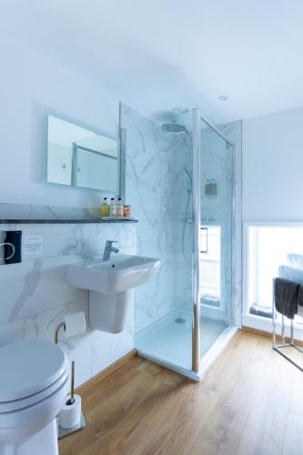 a white bathroom with a sink and a shower at Apartment 6 at Number 8: City centre, 1 bedroom, sofa bed in lounge in Kent