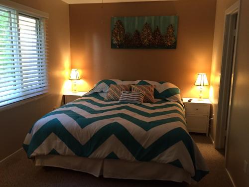 a bedroom with a bed with two lamps on two tables at Villa at Bethany West in Bethany Beach