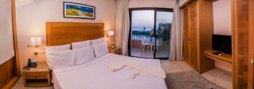 um quarto de hotel com uma cama e uma varanda em Sky View Suites Hotel em Hurghada