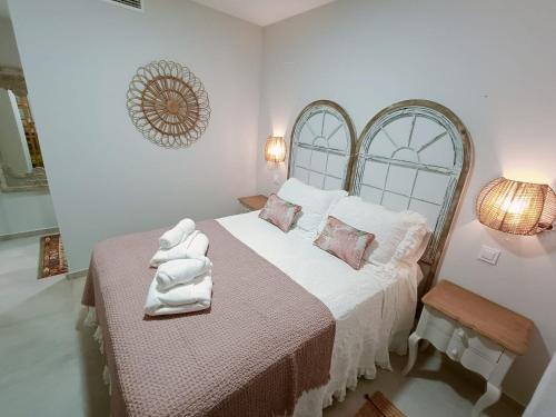 a bedroom with a large bed with white sheets and pink pillows at Malvagon Isla Canela los flamencos in Isla Canela