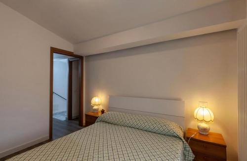 a bedroom with a bed and two lamps on tables at Casa Valentina, casa intera vicino al mare in Carrara