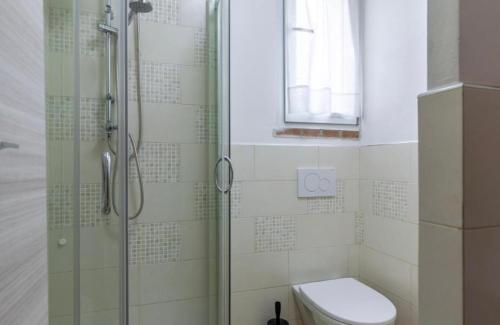 a bathroom with a toilet and a glass shower at Casa Valentina, casa intera vicino al mare in Carrara
