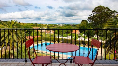 a balcony with a table and chairs and a pool at Resort Camping Santillana del Mar in Santillana del Mar
