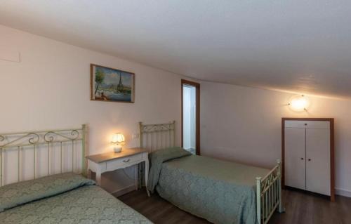 a bedroom with two beds and a desk and a window at Casa Valentina, casa intera vicino al mare in Carrara