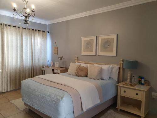 a bedroom with a bed and a chandelier at The Village Inn in Polokwane