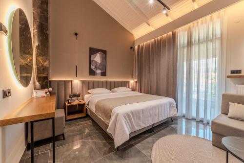 a bedroom with a bed and a desk and a couch at Agnantio Hotel & Spa in Sidirokastro