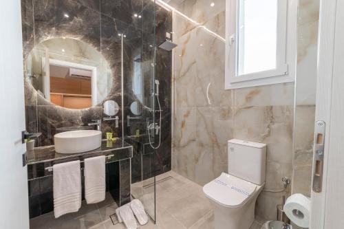 a bathroom with a toilet and a sink and a mirror at Agnantio Hotel & Spa in Sidirokastro