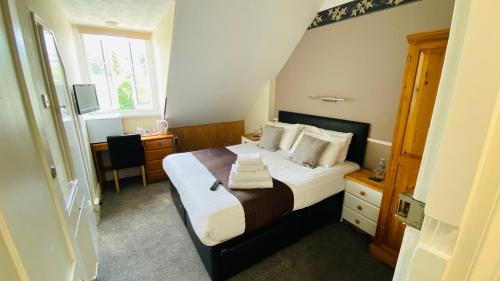 1 dormitorio con cama, escritorio y ventana en Tusker Lodge, en Torquay