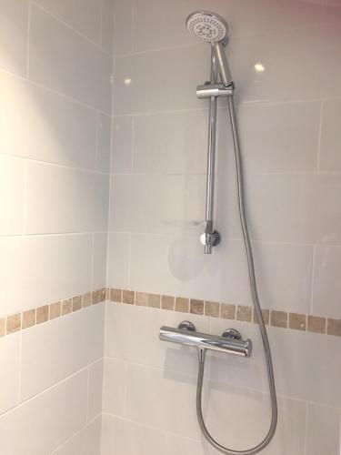 une douche avec pommeau de douche dans une salle de bain dans l'établissement Le Clos De La Perdrix, à Mons-en-Pévèle