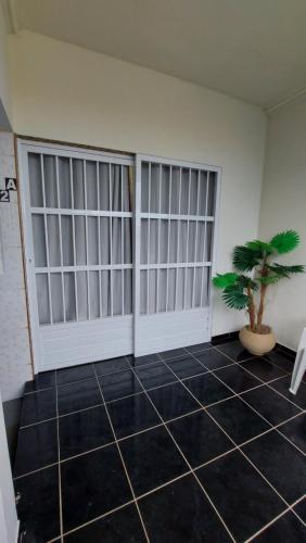 a room with two doors and a potted plant at Flat Atitude no Centro de Maragogi in Maragogi