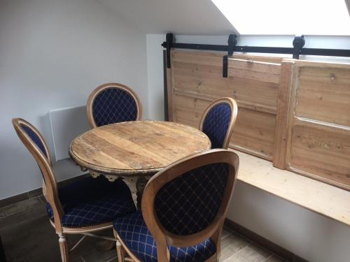 une table et des chaises avec une table en bois, une table et un fauteuil dans l'établissement Le Clos De La Perdrix, 