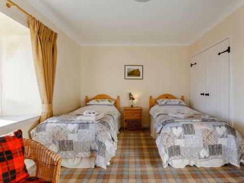 a bedroom with two beds and a window at Craiglea Lodge & Barn in Latheron