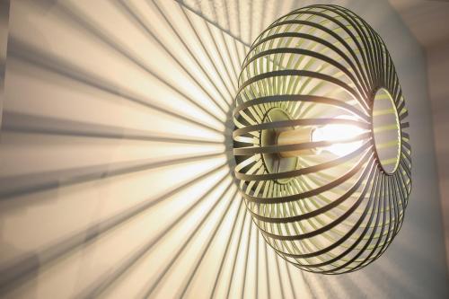 a spiral light hanging from a wall at Ibis Styles Lisieux Normandie in Lisieux