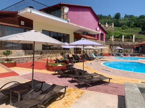 a resort with chairs and umbrellas and a swimming pool at Hotel Loggas in Sidhirokhórion