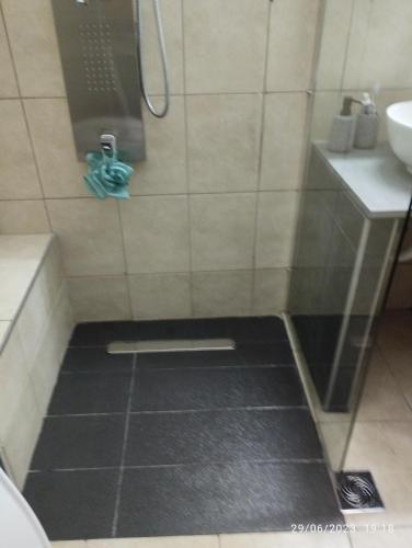 a shower with a black floor in a bathroom at Mavridis House in Eleftheroúpolis