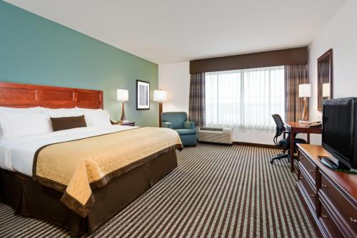 a hotel room with a bed and a flat screen tv at Baymont by Wyndham Denver International Airport in Denver