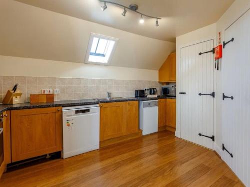 a large kitchen with wooden cabinets and a window at Craiglea Lodge & Barn in Latheron