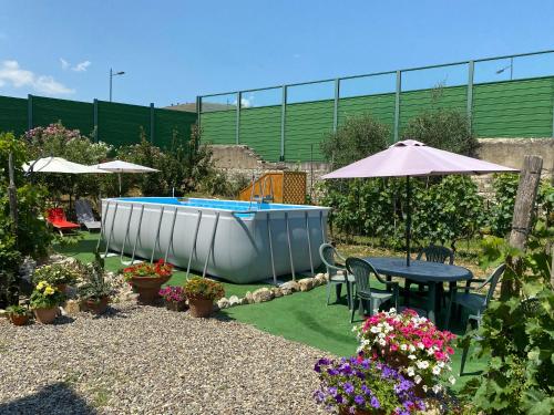 a garden with a swimming pool and a table and umbrella at Residenza San Matteo in Calenzano