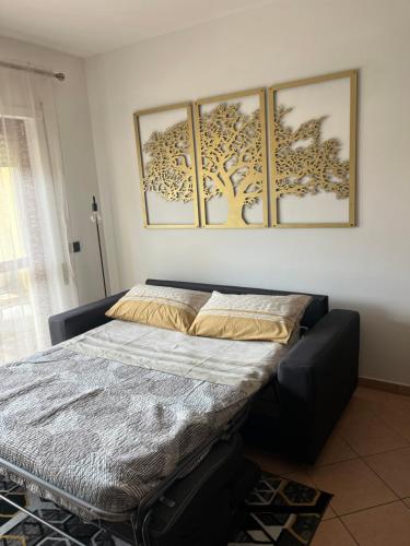 a bed in a room with four pictures on the wall at Casa Palma in San Donato