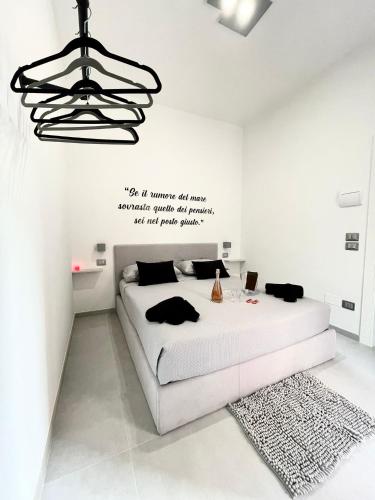 a white bedroom with a bed and a chandelier at El Puerto B&B in Vieste