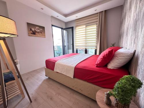 a bedroom with a bed with red sheets and a window at Beautiful house close to the sea in the center of MERSİN in Mersin