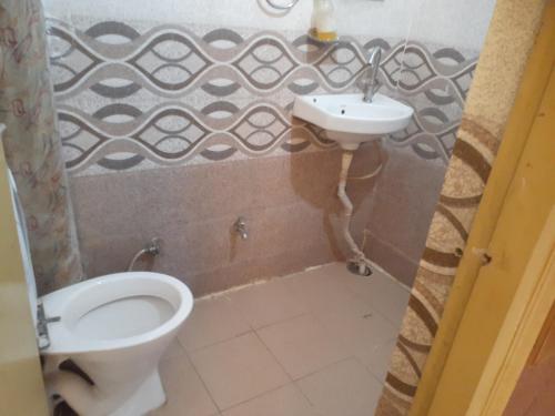 a bathroom with a toilet and a sink at Hotel Rattans Regency in Roorkee
