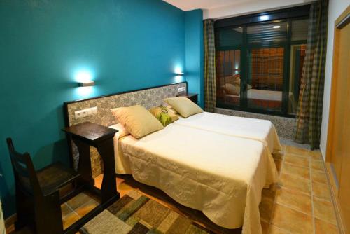 um quarto com uma cama, uma mesa e uma janela em Apartamentos Turisticos Dormi2 em Zamora