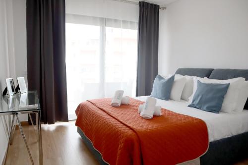 een slaapkamer met een groot bed met 2 afstandsbedieningen bij Monte da Ondas by ALgest in Portimão