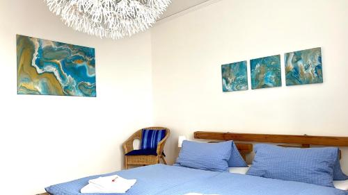een slaapkamer met een blauw bed en een kroonluchter bij Frau Holle in Wolfhagen