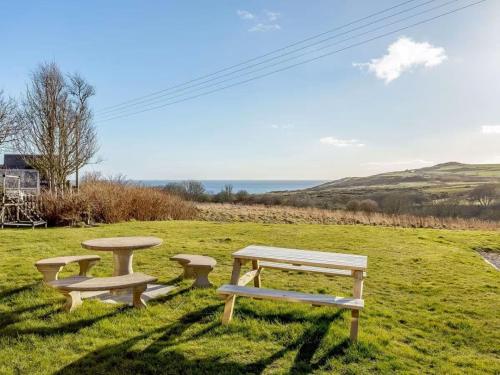 a picnic table and benches in a field at Craiglea Lodge & Barn in Latheron
