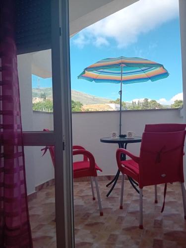 a patio with a table and an umbrella and chairs at Vila Centar in Trebinje