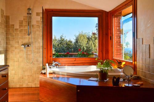 ein Bad mit einer Badewanne und einem großen Fenster in der Unterkunft Fantástica casa con vistas al mar in Arenys de Munt