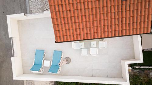 dwa niebieskie krzesła na boku budynku w obiekcie Bruno's Poolside Retreat w Trogirze
