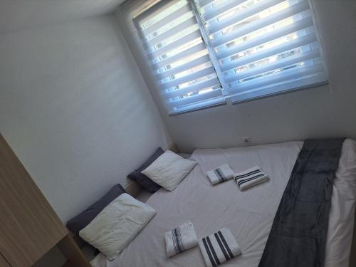 a bedroom with a bed with two pillows and a window at Vila Gavrić in Zvornik
