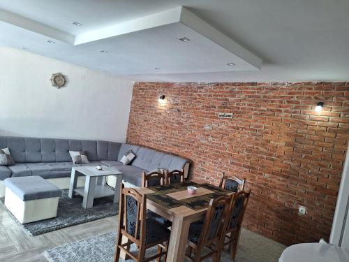 a living room with a couch and a brick wall at Vila Gavrić in Zvornik