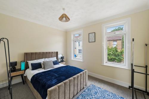 a bedroom with a bed and two windows at Brun Clair House in Chatham