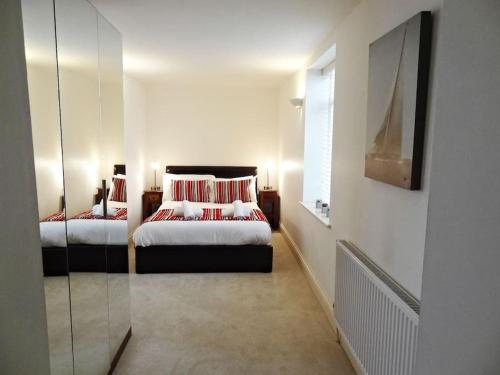 - une chambre avec 2 lits et un miroir dans l'établissement No5 - by Crown Gardens Holiday Homes, à Brighton et Hove