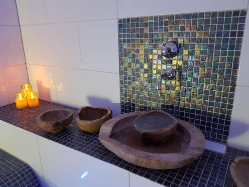 baño con lavabo de madera y 3 velas en Waterhill's Bed & Wellness en Dinteloord