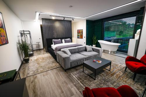 a living room with a couch and a bed and a tub at Çathan Art Hotel in Ayder Yaylasi