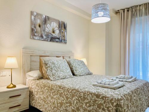 a bedroom with a bed and a lamp and a window at Alborán Costa del Sol in Estepona