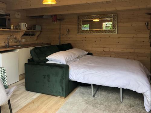 een bed in de hoek van een kamer bij Cosy Garden Log Cabin in Salisbury