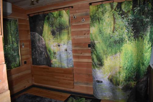 una habitación con dos pinturas en la pared en La cabane aux écureuils en Philippeville
