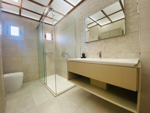 La salle de bains est pourvue d'un lavabo, d'une douche et de toilettes. dans l'établissement Villa Anita features privacy, sea views and private pool, à San Roque