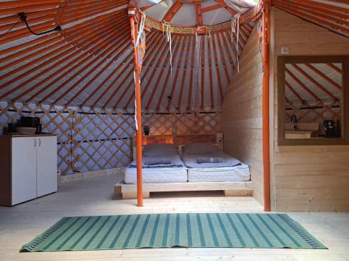 a bedroom in a yurt with a bed in it at Foxódi Lombjurta in Taliándörögd