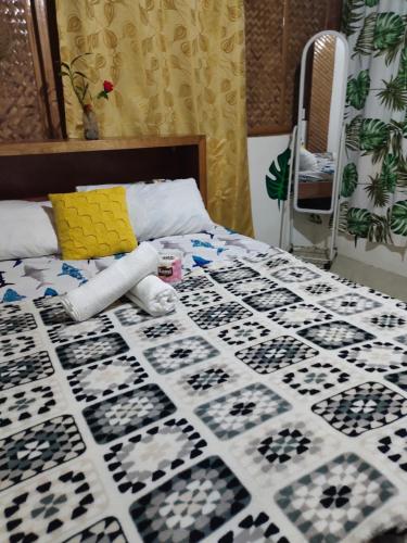 a bed with a black and white quilt on it at Reggae Vibes De Romblon in Agpanabat