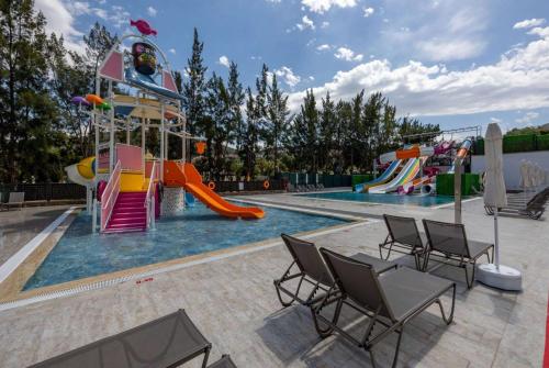 een zwembad met een speeltuin met een glijbaan bij Ramada Hotel & Suites by Wyndham Kusadasi in Kuşadası