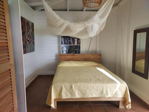 a bedroom with a bed with a drape over it at la villa caribéenne de la plage des surfeurs in La Trinité