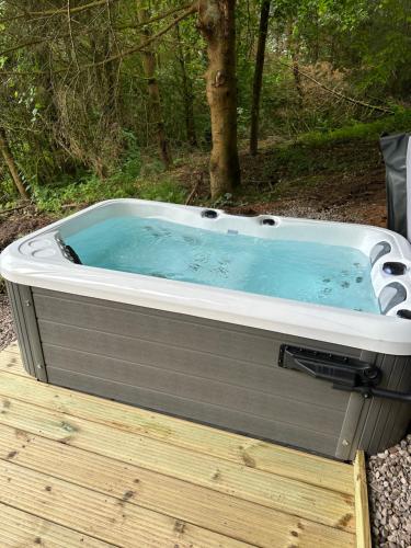 a hot tub sitting on top of a wooden deck at Unique Orchard Lodge for couples with hot tub in Strathaven